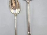 two silver spoons and a spoon on a table