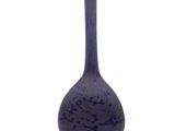 un vase bleu posé sur une surface blanche