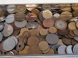 un récipient en métal rempli de pièces de monnaie posé sur une table