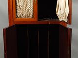 une petite armoire munie d'une porte et d'un rideau