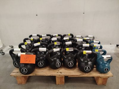 many kettle weights sitting on a pallet in a warehouse