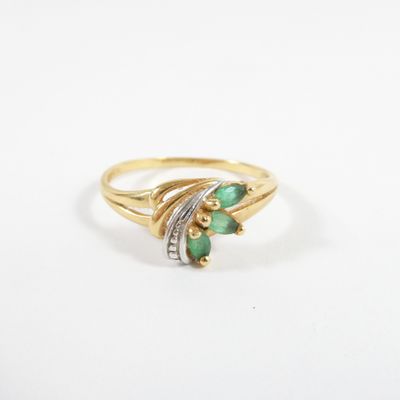 a gold ring with emerald stones and diamonds