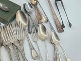 a lot of silver spoons and silverware on the table