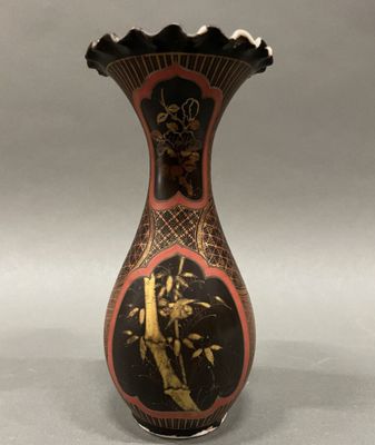 a black and red vase with gold designs on it