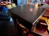 a black table with a glass of beer on it
