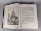 an open book with a drawing of a church in the background