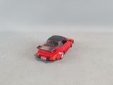 a red toy car that is sitting on a white surface