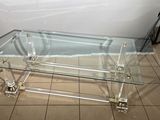 une table basse en verre posée sur un sol carrelé dans une pièce