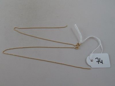 three gold necklaces with a price tag on a white background