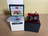 a toy tractor sitting next to a box on a table