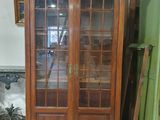 un grand meuble en bois avec des portes en verre dans une pièce