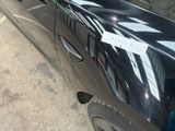 a black car with a sticker on it parked in a parking lot