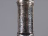 a silver vase with a silver lid on a table
