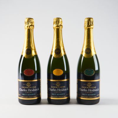 trois bouteilles de champagne sont alignées sur un fond blanc