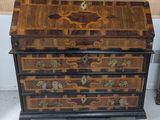 une petite commode en bois ornée de motifs dorés