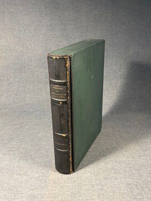 a green book sitting on top of a table next to a gray wall