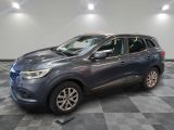 une voiture grise est garée dans une pièce au sol à carreaux
