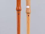 pair of wooden flutes on display on clear acrylic stand