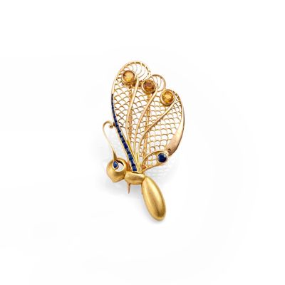 a close up of a gold broochle with blue stones on it