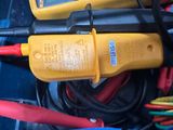 two multimeters in a blue container with wires and wires