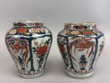 pair of chinese vases with floral designs on them on a white surface