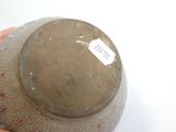 a person holding a brown vase with a tag on it