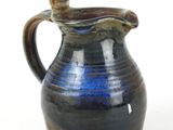 a blue and brown pitcher with a cat on it