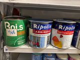 Plusieurs pots de peinture sont posés sur une étagère dans un magasin.