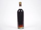 une bouteille d'alcool posée sur une surface blanche