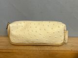 a white purse sitting on top of a wooden table next to a wall