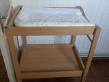 a small wooden table with a baby ' s crib on it