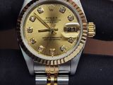 a gold and silver wrist watch with diamonds on it