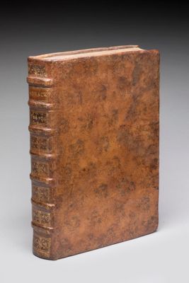 un vieux livre posé sur une surface blanche