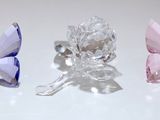 trois papillons en cristal posés sur une surface blanche