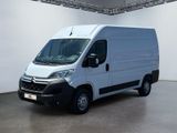La camionnette blanche est garée dans une grande pièce d'un immeuble.