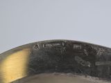 a close up of a metal bowl with a spoon in it