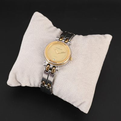 une photo d'une montre-bracelet posée sur un oreiller, sur un fond noir