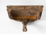 an old wooden shelf with two hooks on the side of it