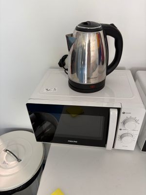un micro-ondes sur lequel est posée une théière