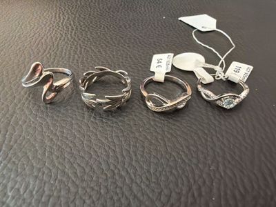 three rings and a key are sitting on a leather surface