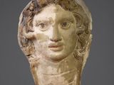 head of a woman with curly hair on a stand