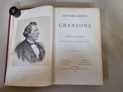 un livre ouvert sur lequel figure la photo d'un homme en costume et nœud papillon
