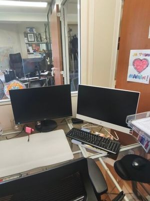 a desk with two computer monitors and a keyboard on it
