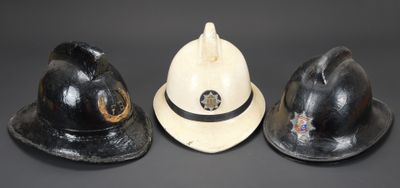 trois casques de pompier sont alignés sur un fond noir