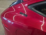 a close up of a red car with a sticker on it