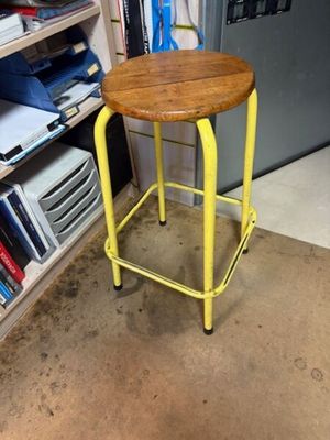 a yellow stool with a wooden seat in a room