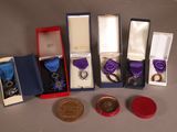cinq médailles et une médaille dans une boîte posée sur une table