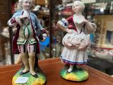 two figurines of a man and a woman standing on a table