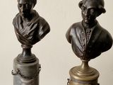 two bronze busturines of a man and a woman sitting on a table