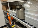 de nombreuses casseroles et poêles sur les étagères de la cuisine